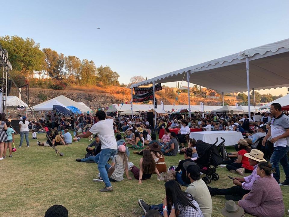 Área de stands gastronómicos con carpas y público
