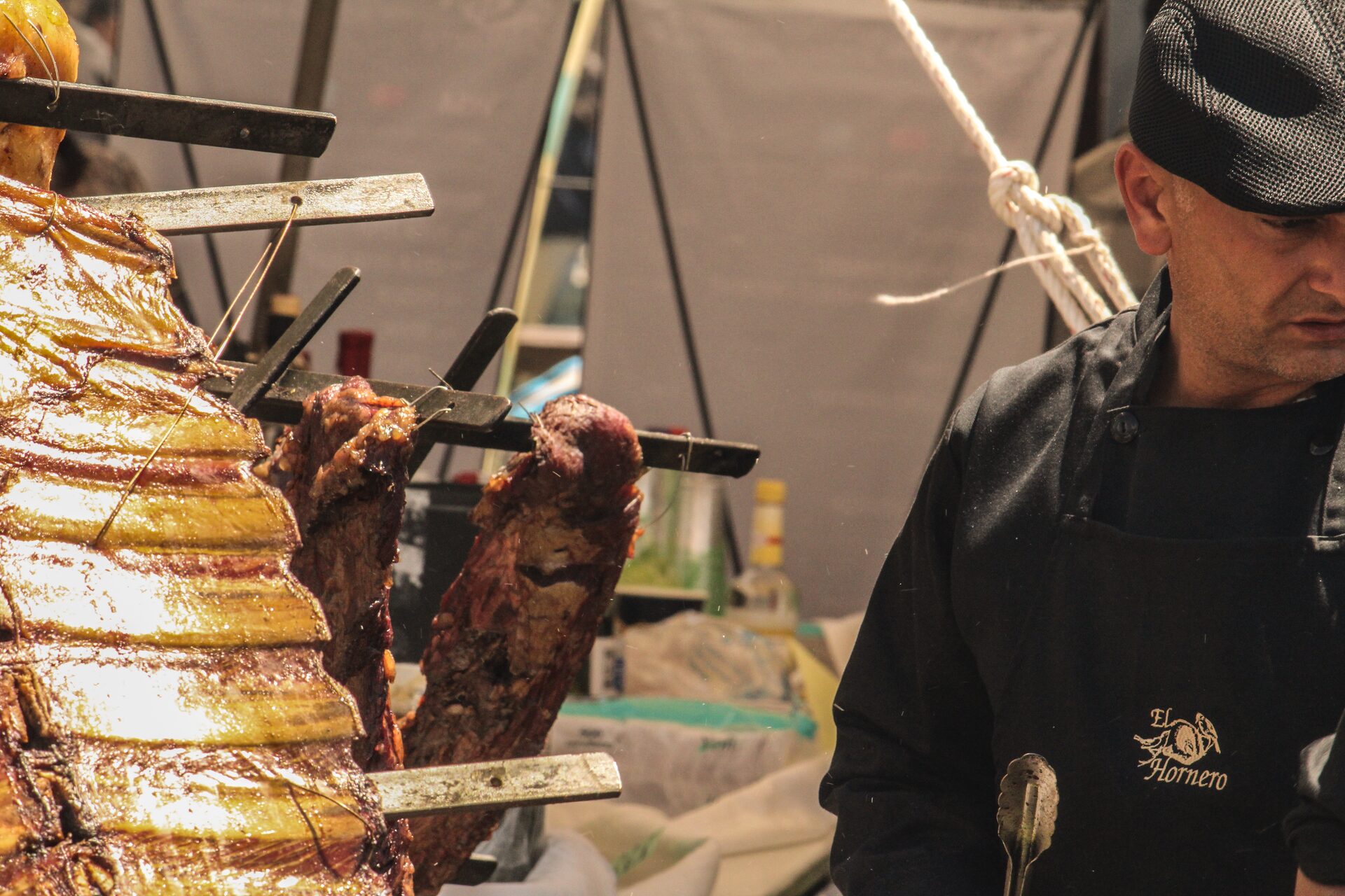 Parrillero preparando cortes en su stand con bandera mexicana