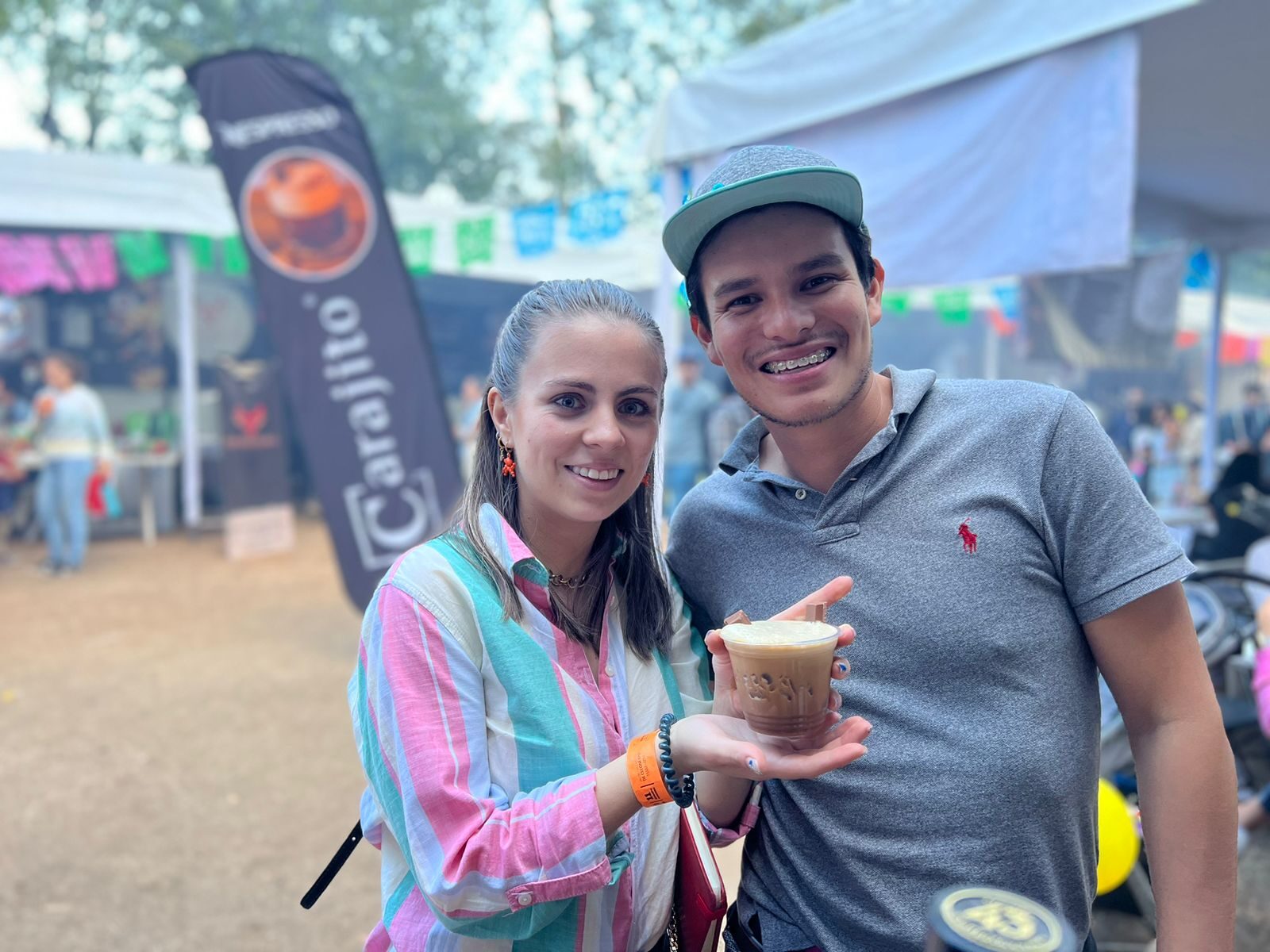 Público sentado en mesas disfrutando la comida del festival