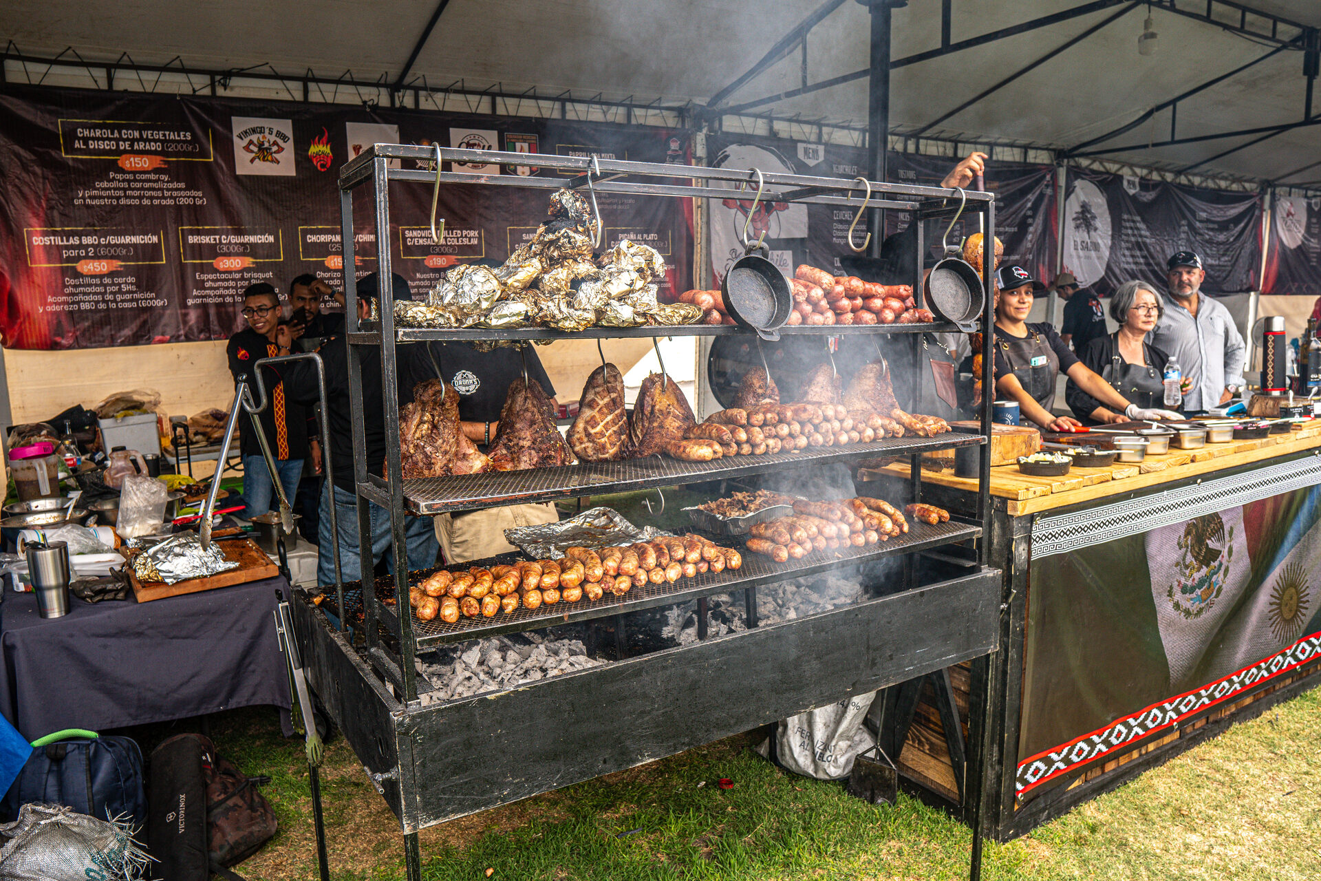 Carnes doradas asándose sobre parrilla con humo