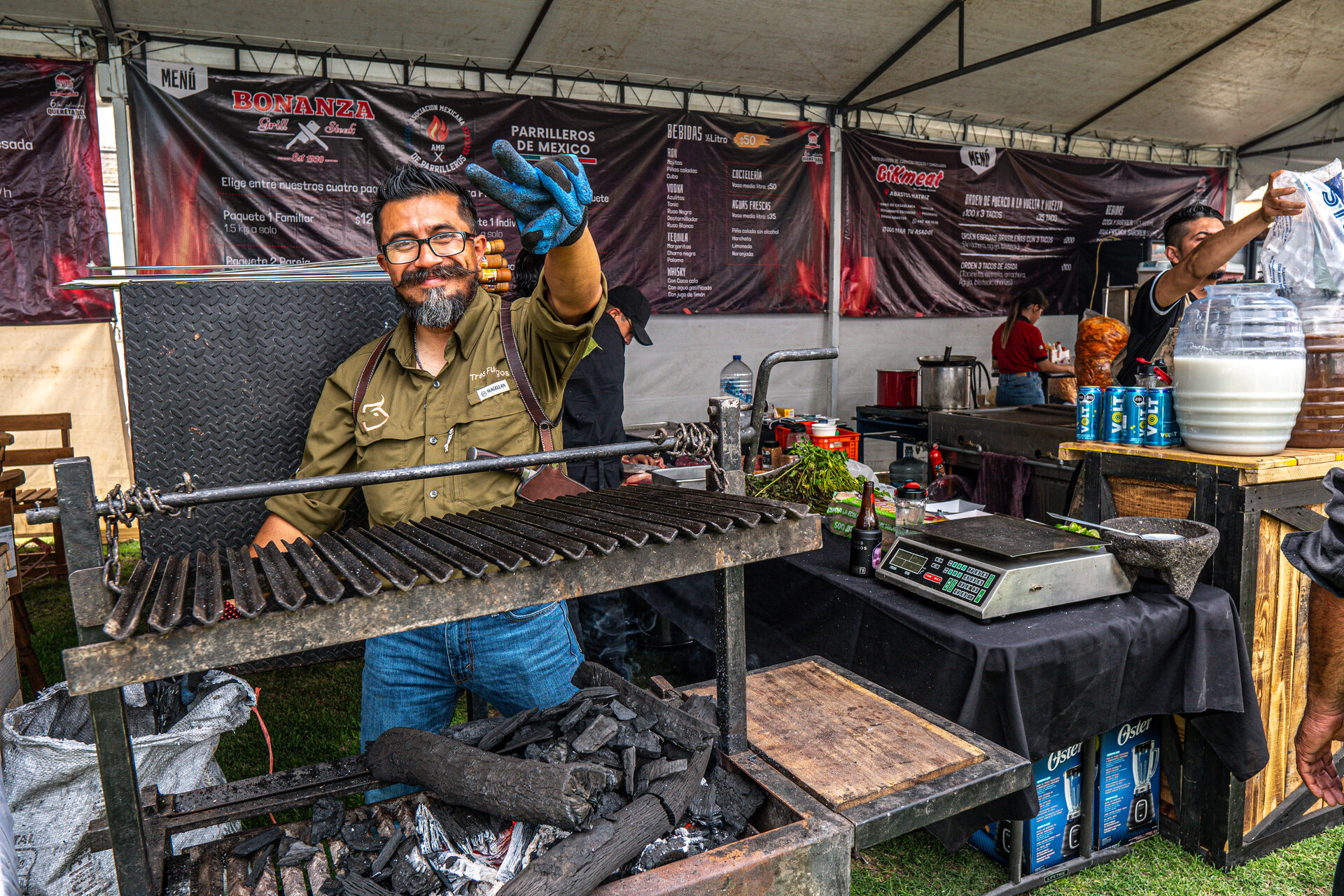 Pareja de asadores coordinando el fuego en su stand
